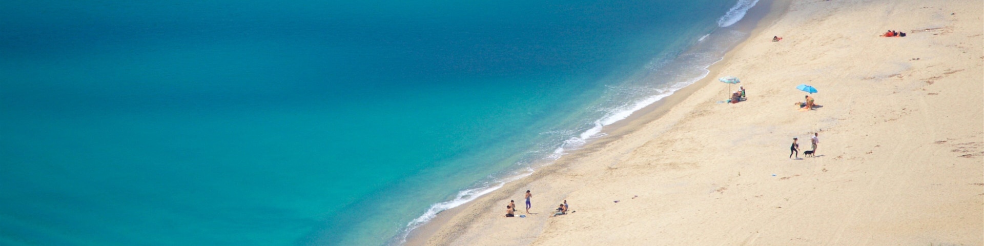 Caminia Beach which includes general coastal views and a sandy beach as well as a small group of people