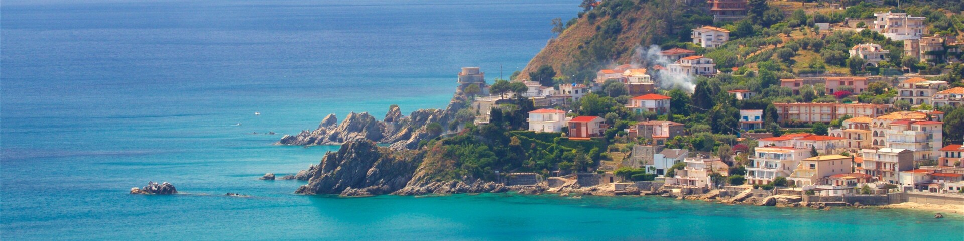 Un pueblo costero con edificios en una ladera con vista al mar.