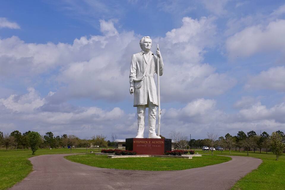 Une statue de Stephen F. Austin, qualifié de « père du Texas », se trouve dans un parc agrémenté d’un sentier sinueux et de verdure.
