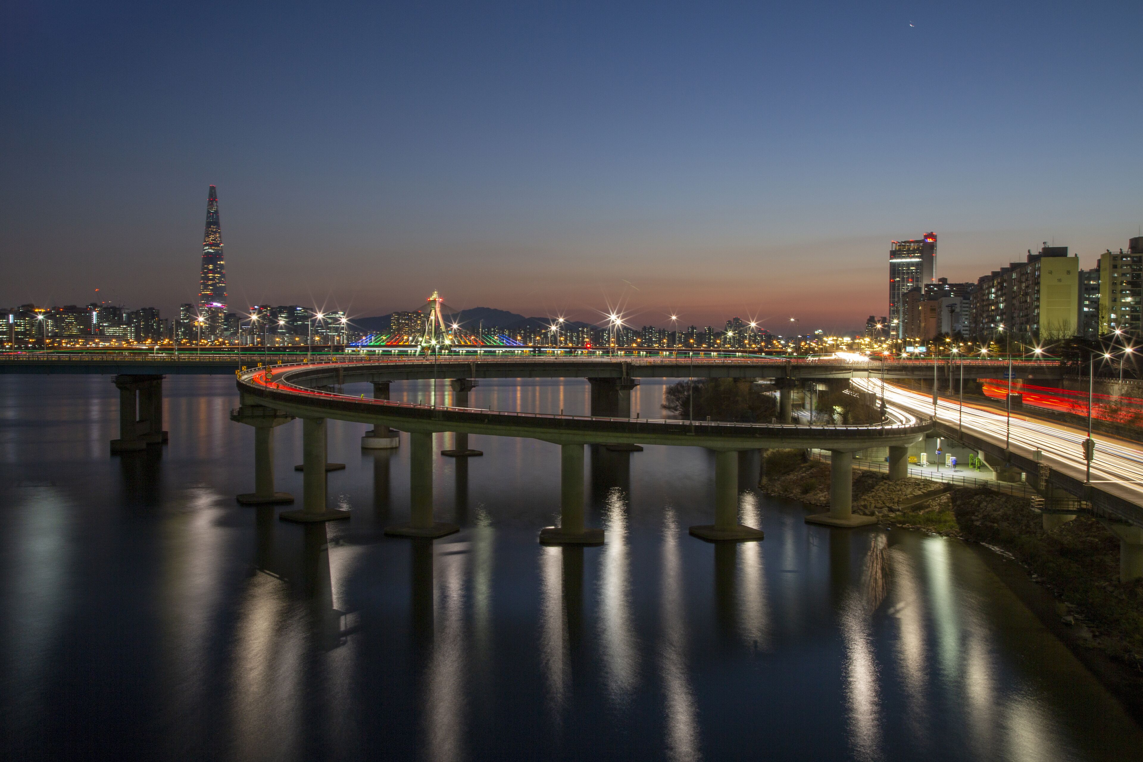 Gwangjin-gu, Seoul, South Korea - December 20, 2020: Night view of Cheonho Bridge and Gangbyeon Expressway on Han River with the background of Olympic Bridge and Lotte World Tower