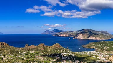 A coastal town with a harbor, mountains, and a clear blue sky.
