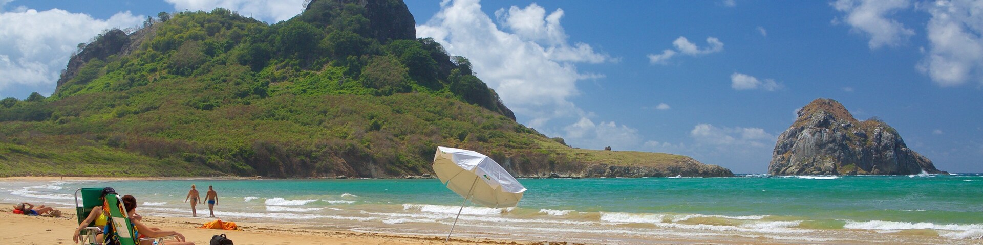 Praia do Sueste que inclui uma praia de areia, ondas e paisagens da ilha