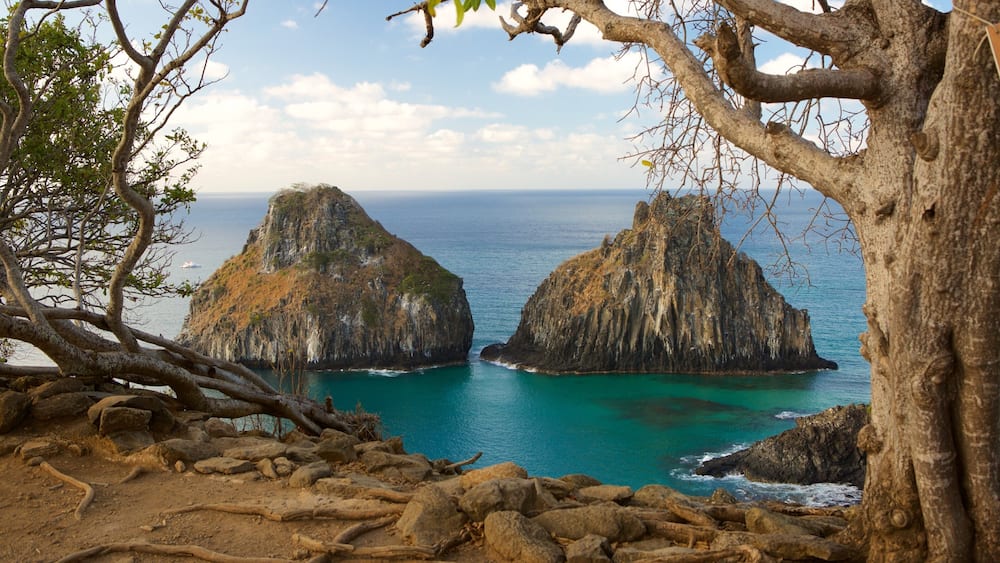 Un paysage côtier caractérisé par deux formations rocheuses imposantes, entourées d’eaux turquoise.