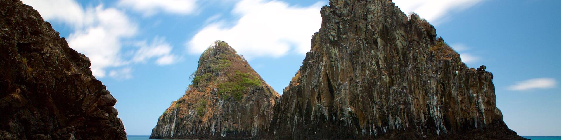 Dois Irmaos Hill which includes rocky coastline, a beach and general coastal views