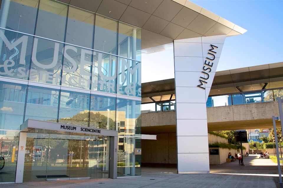 A modern glass building with the words "MUSEUM SCIENCE CENTRE" on the facade.