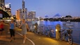 A cityscape at dusk with a lit bridge and skyscrapers.