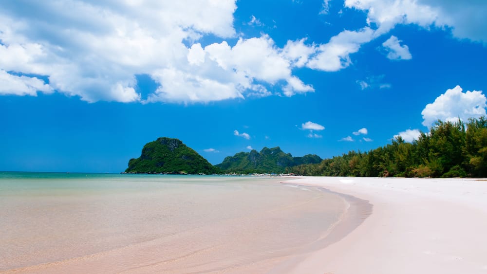 Tropical island white sand beach with blue sky and clouds in summer