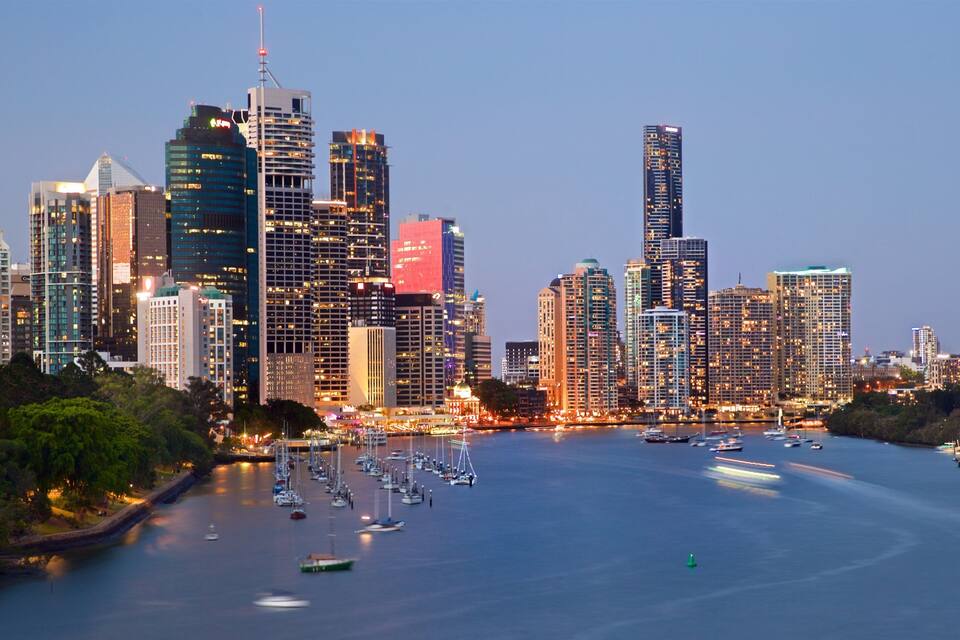 A city skyline with tall buildings and a marina filled with boats.