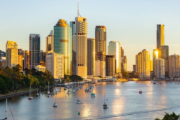 A city skyline with tall buildings and a marina filled with boats.