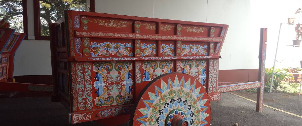 A colorful, intricately decorated cart with a large, ornate wheel.