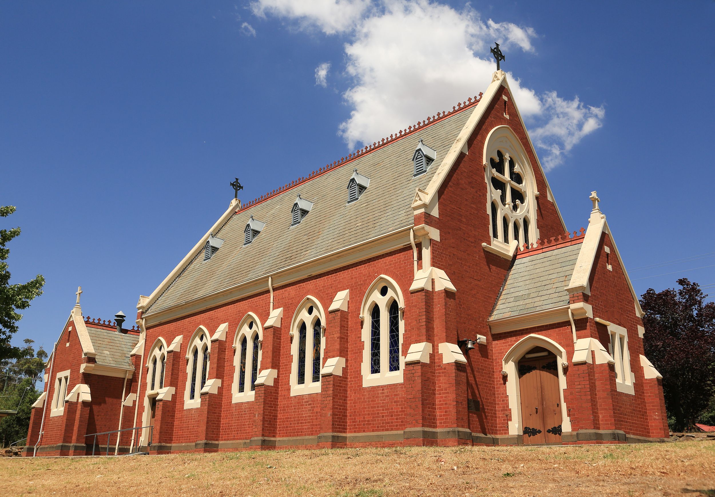 A red brick church with white trim and multiple arched windows.
