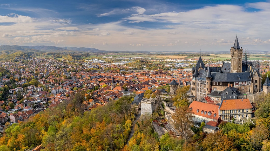 A panoramic view of a town with a prominent tower and surrounding hills.