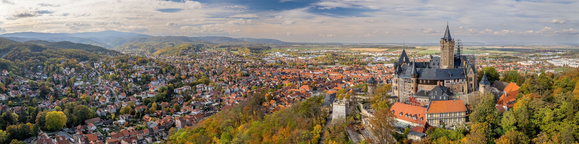 Vista panorámica de un pueblo con una torre destacada y colinas circundantes.