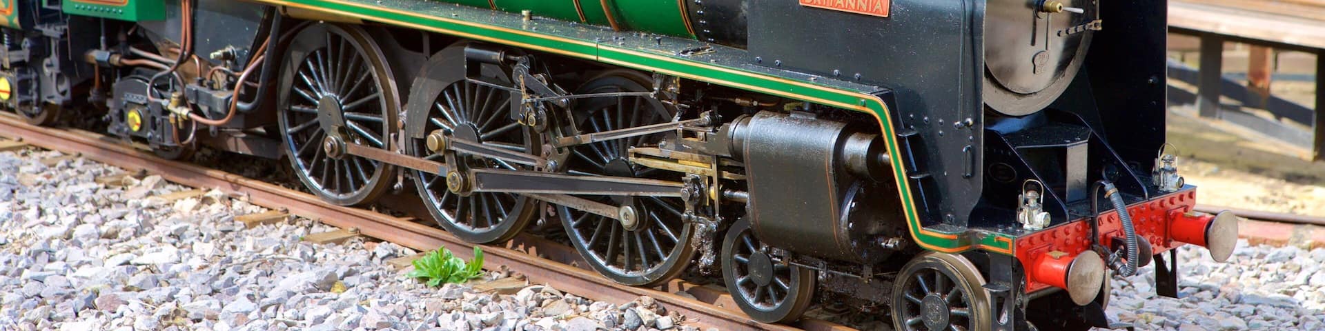 A green and black BRITANNIA steam locomotive on a railway track.