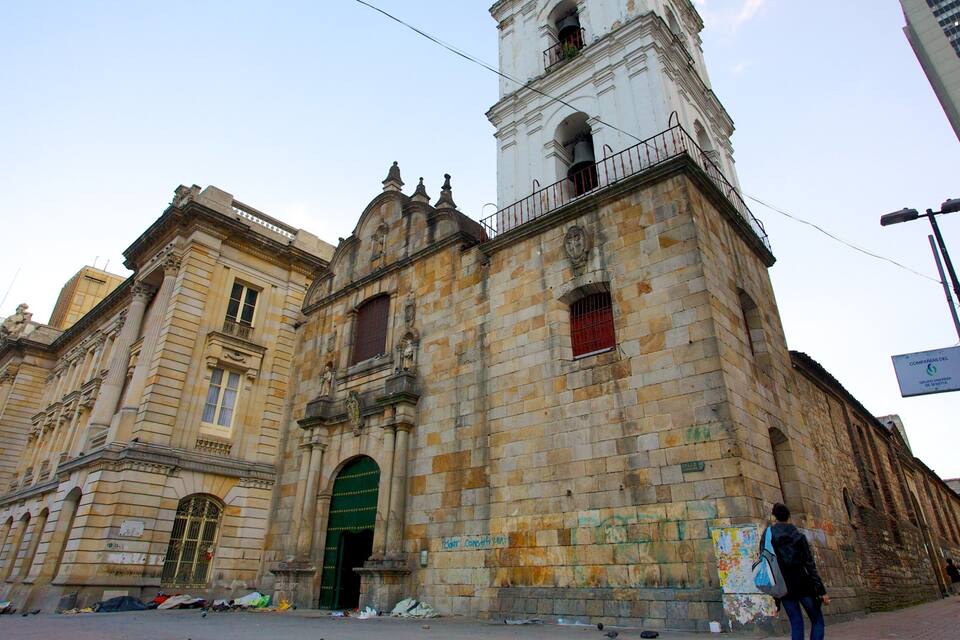 Um edifício histórico com uma torre de sino e entrada verde.