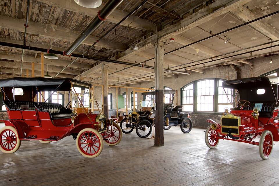 A vintage car museum with antique cars on display.