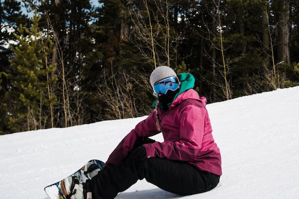 Woman Snowboarder Resting On The Snow