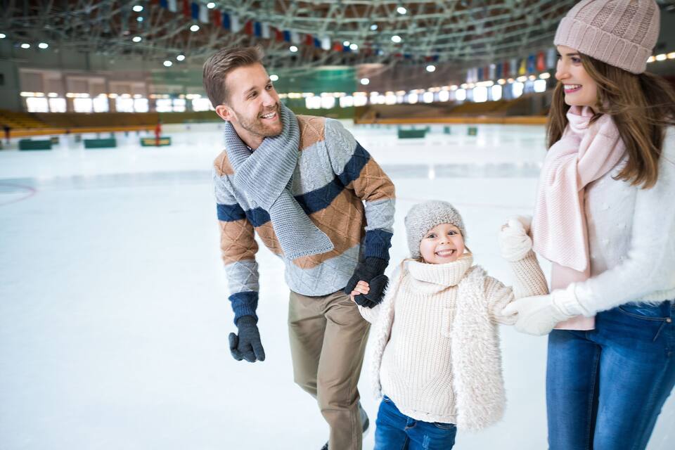 Une patinoire intérieure avec un plafond haut et des drapeaux.