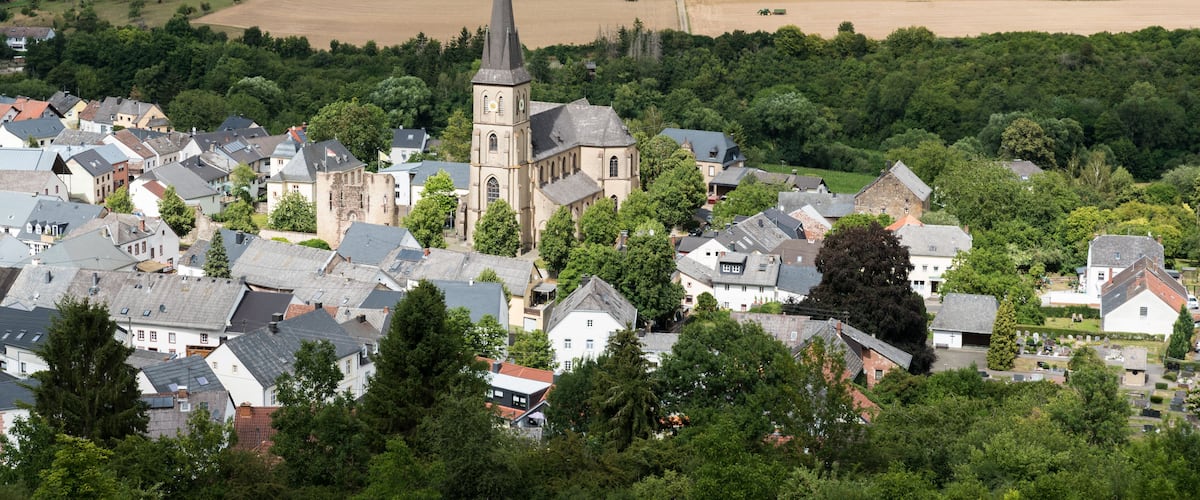 A town with a prominent church, surrounded by fields and greenery.