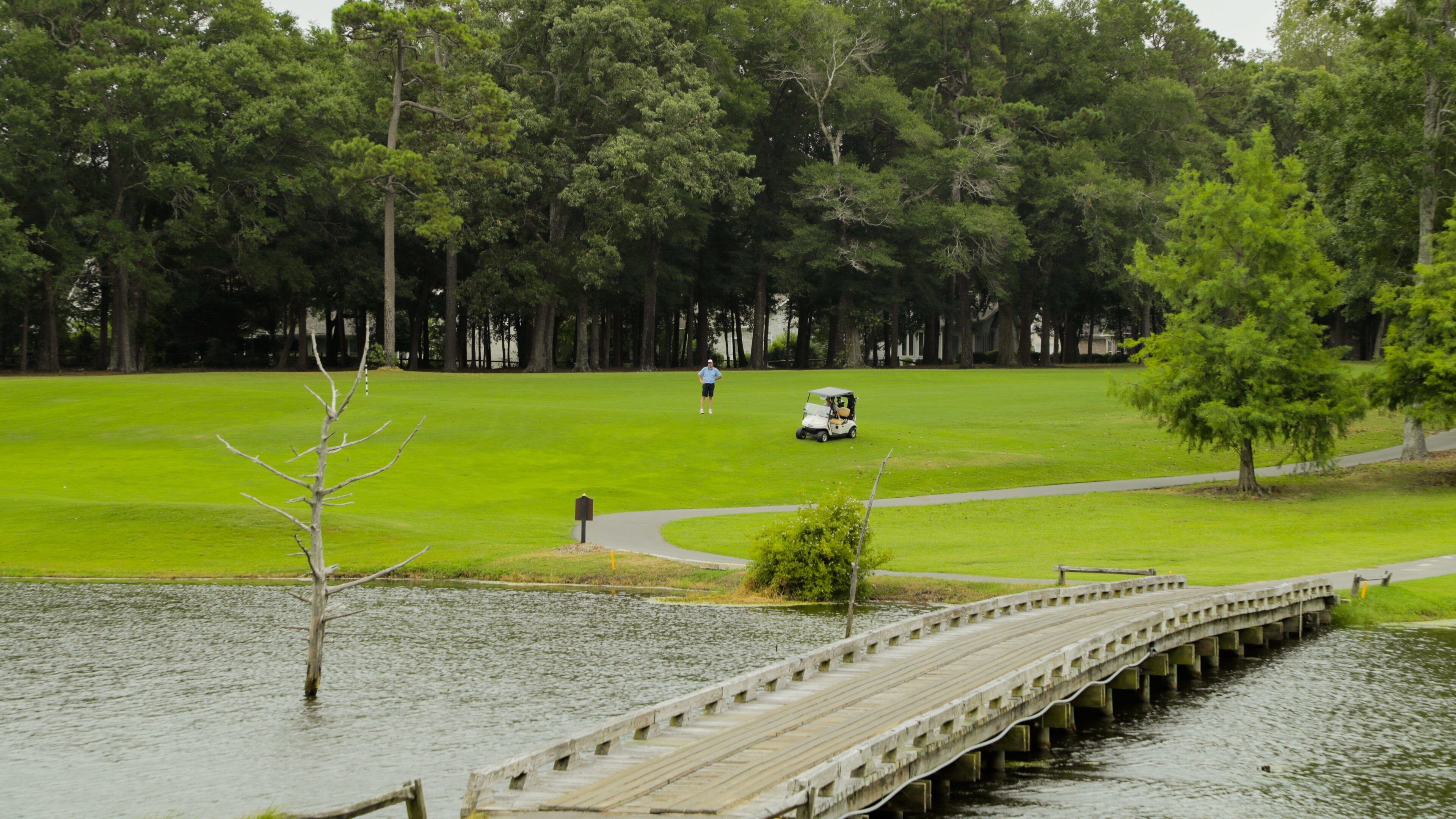Arcadian Shores Golf Club which includes golf, a bridge and a pond