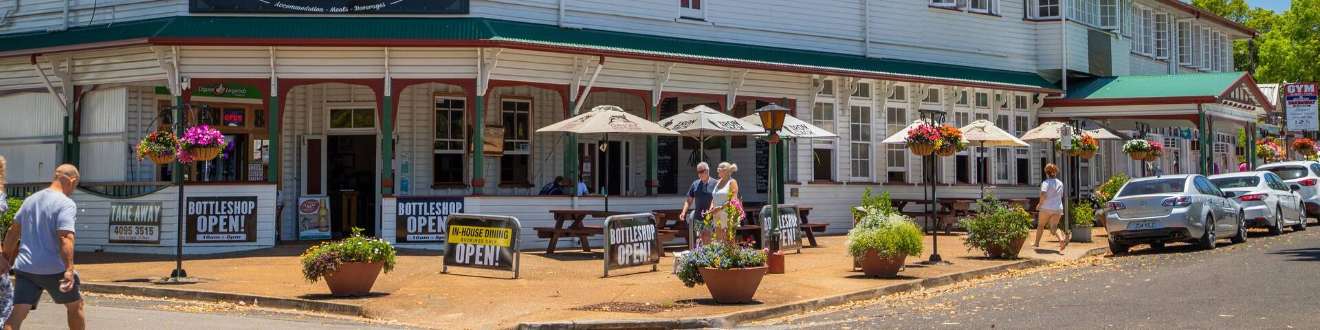 The Yungaburra Hotel with outdoor seating and a signboard advertising 'Bottleshop Open'.