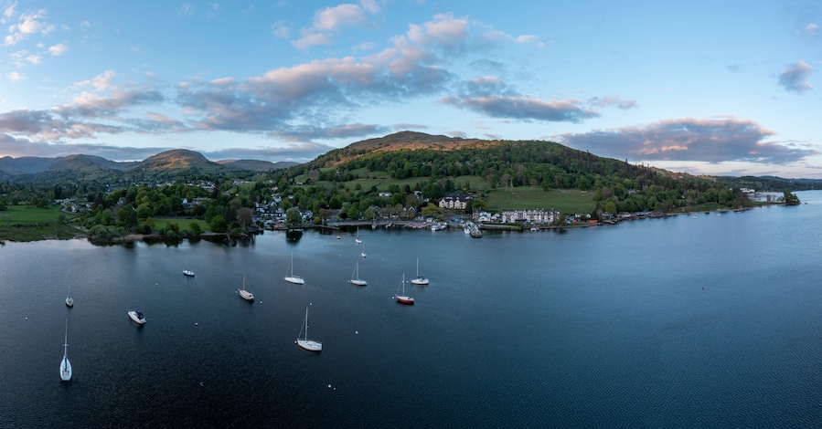 elevated view of sunset over lake windermere at waterhead ambleside looking over the town towards the hill range known as the fairfield horseshoe on the left and wansfell centre