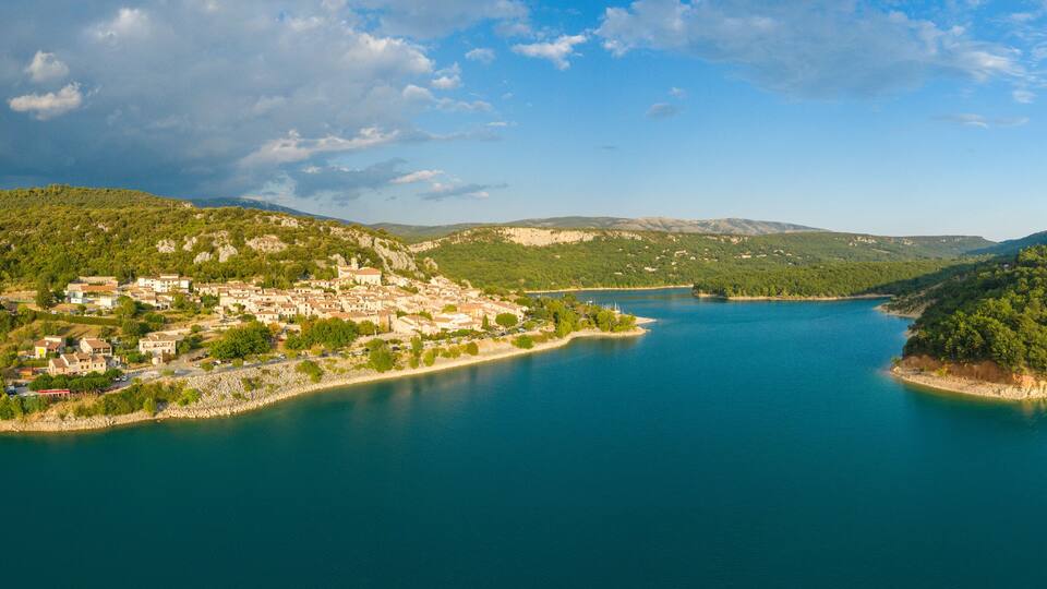 A coastal town with a lake, surrounded by hills and mountains.