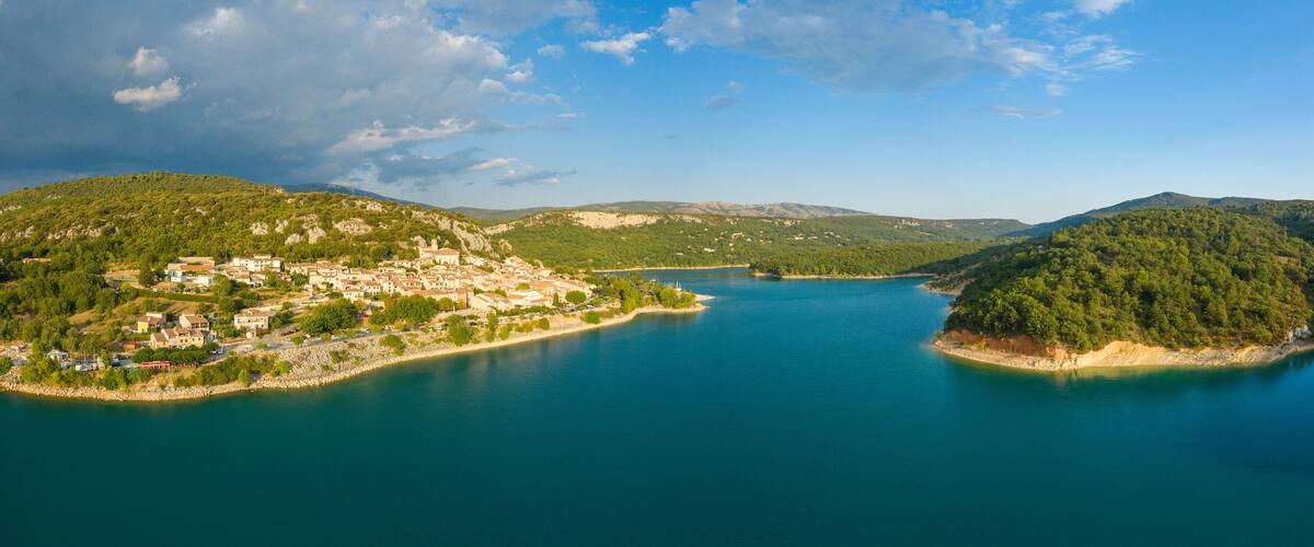 A coastal town with a lake, surrounded by hills and mountains.