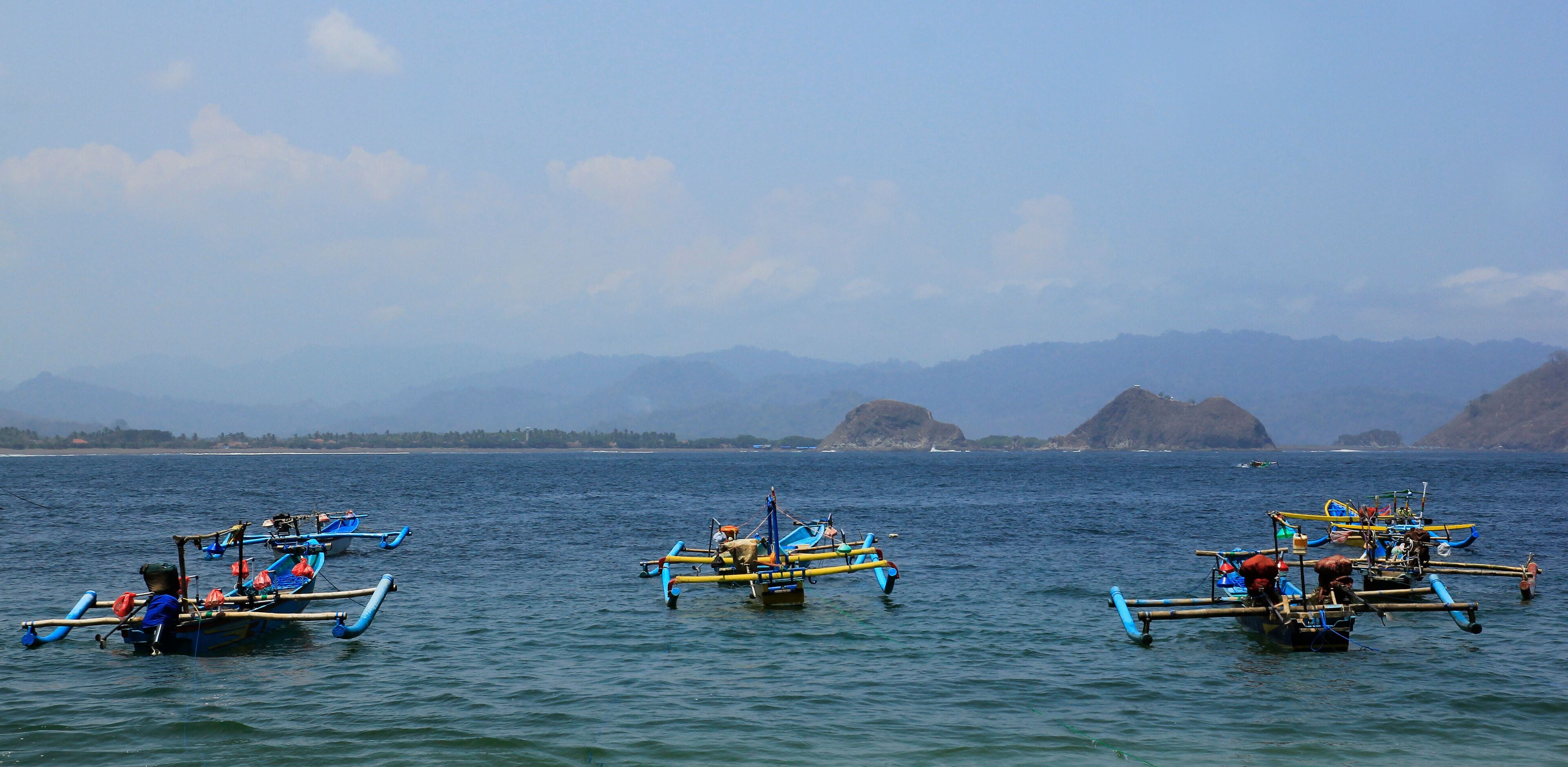 Jember, Indonesia, Sept 12, 2015. Traditional fishing boats sailing over the coastal waters of Tanjung Papuma