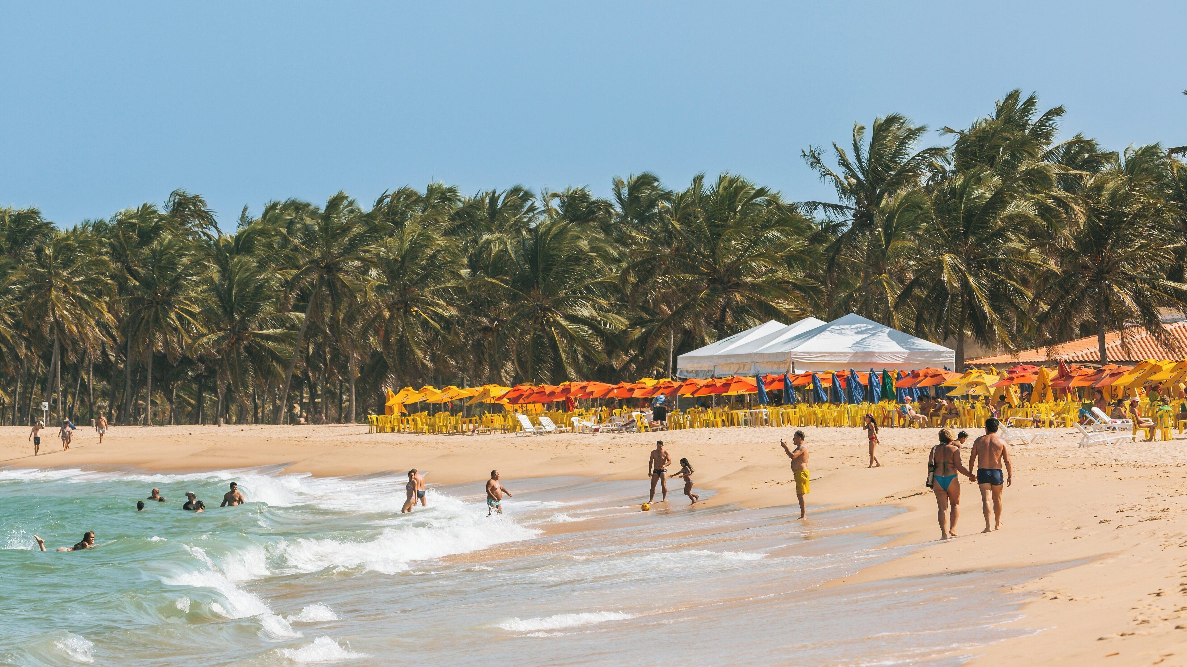 Gunga Beach in Maceio, Alagoas, Brazil offers vibrant umbrellas and visitors enjoying sun and surf on a bright day