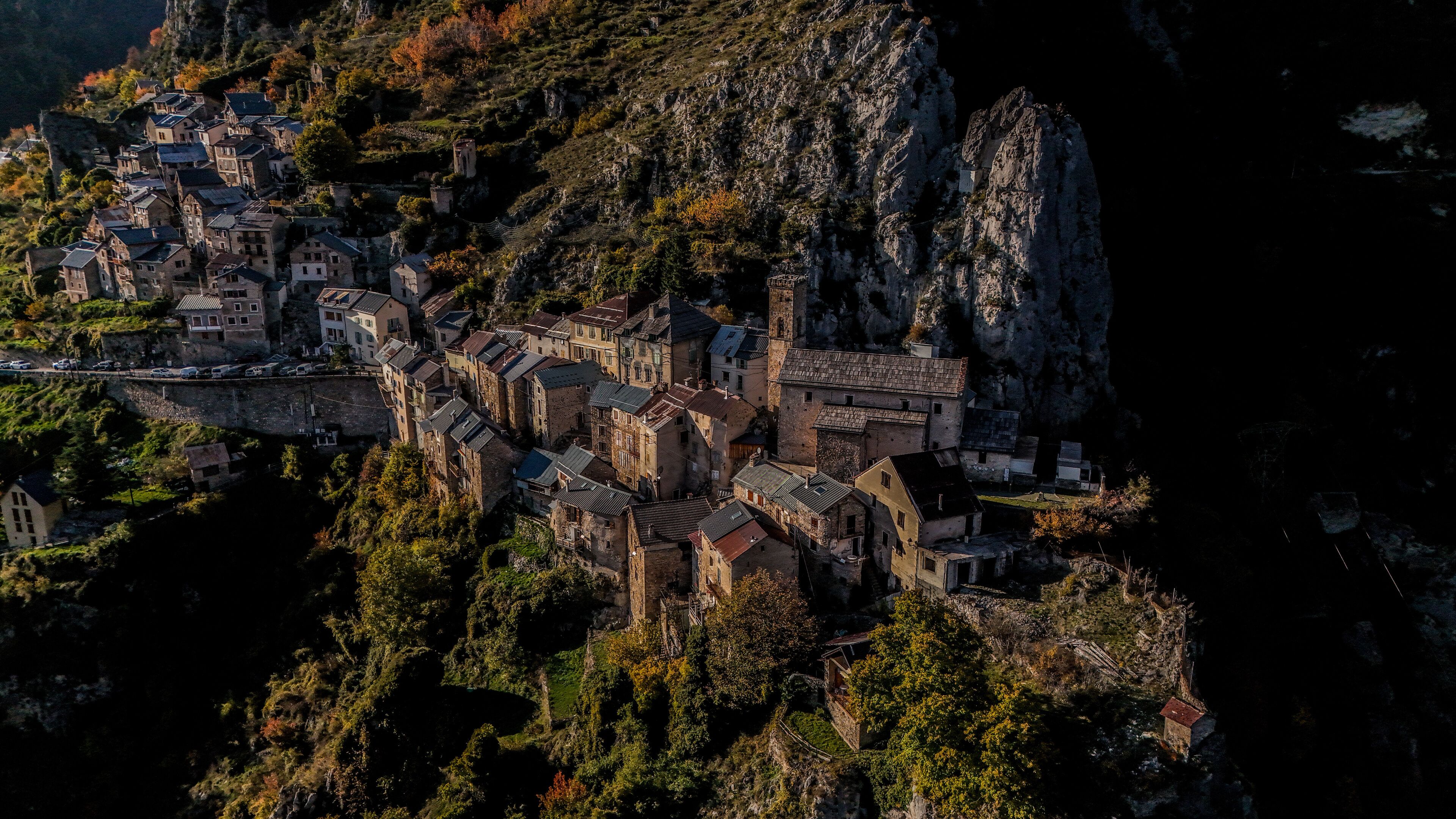A mountainous village with stone buildings perched on a cliff.