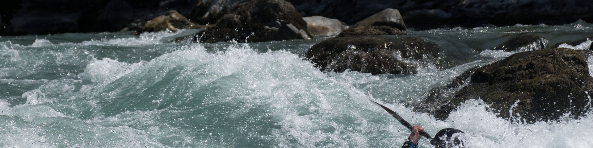 Kayaker playboating at the Rabioux, on the Durance river (France).