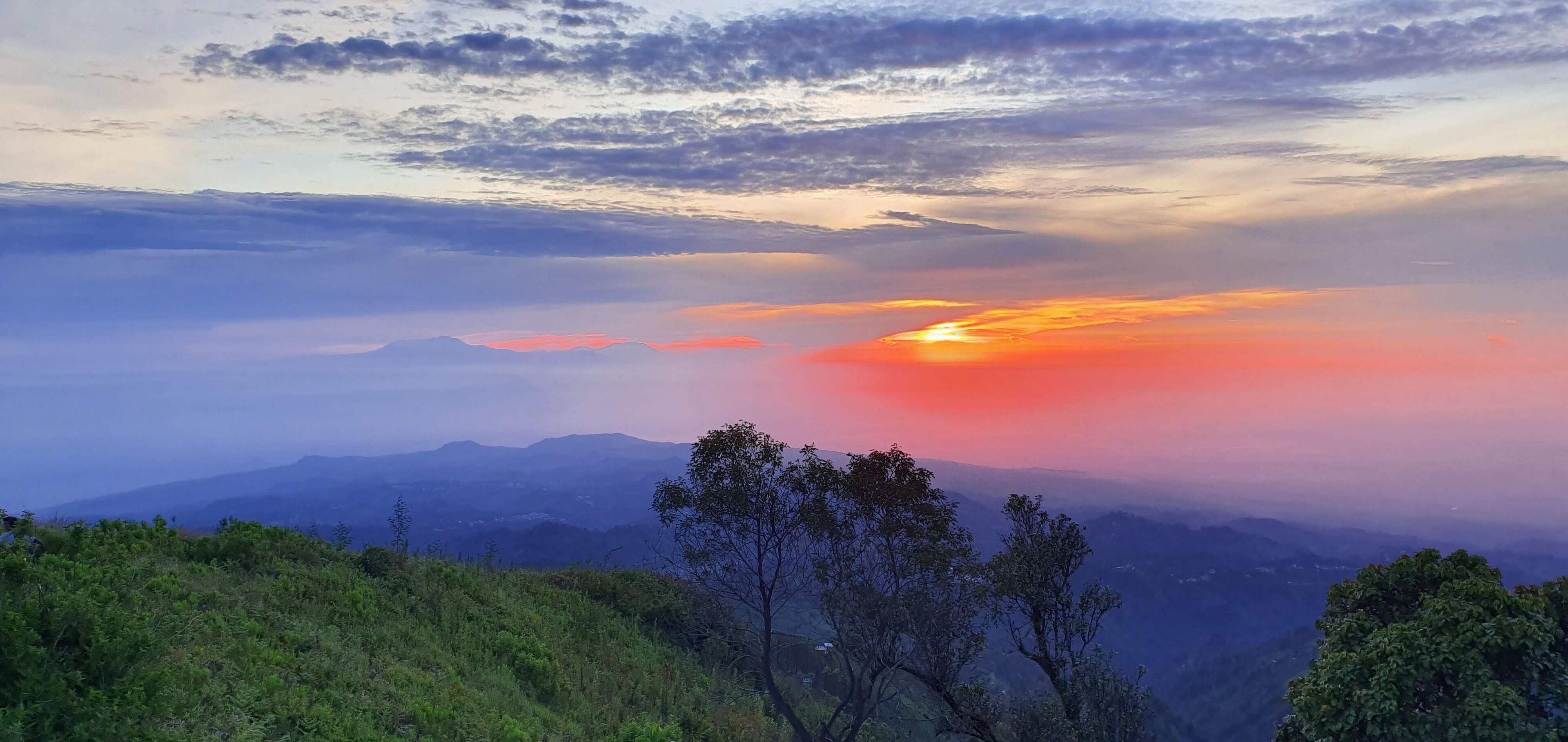 A mountainous landscape with a sunset.