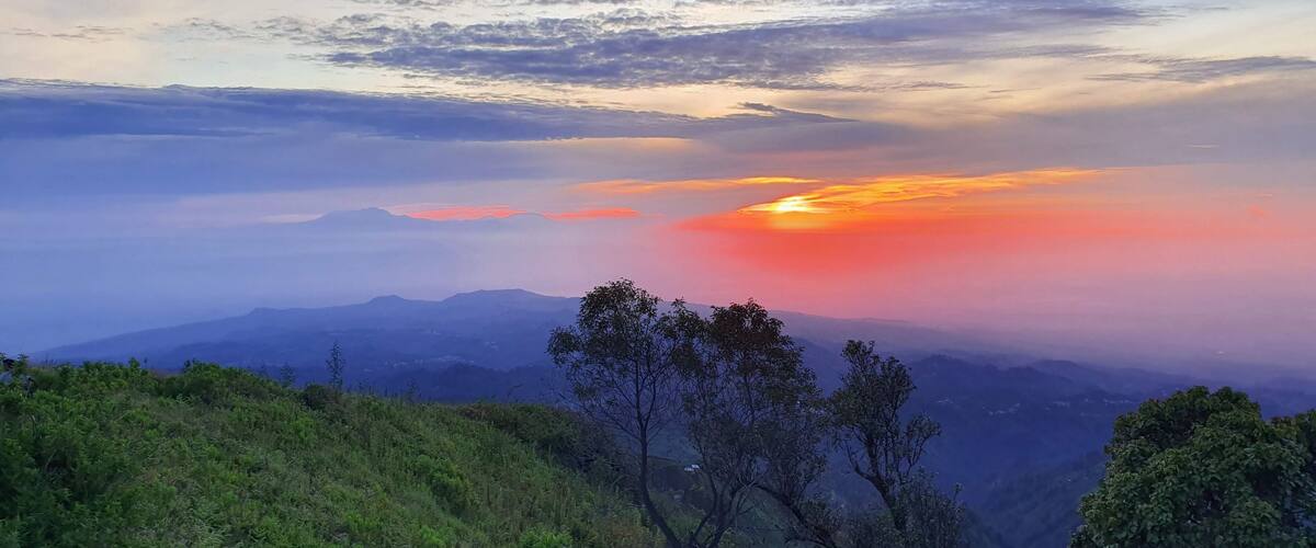 A mountainous landscape with a sunset.