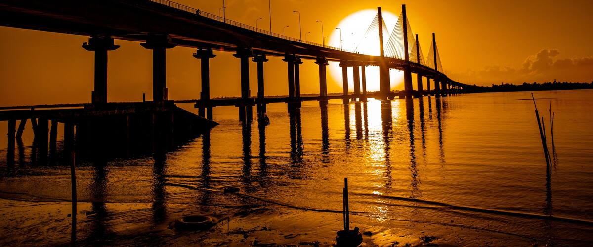 A bridge over water at sunset.