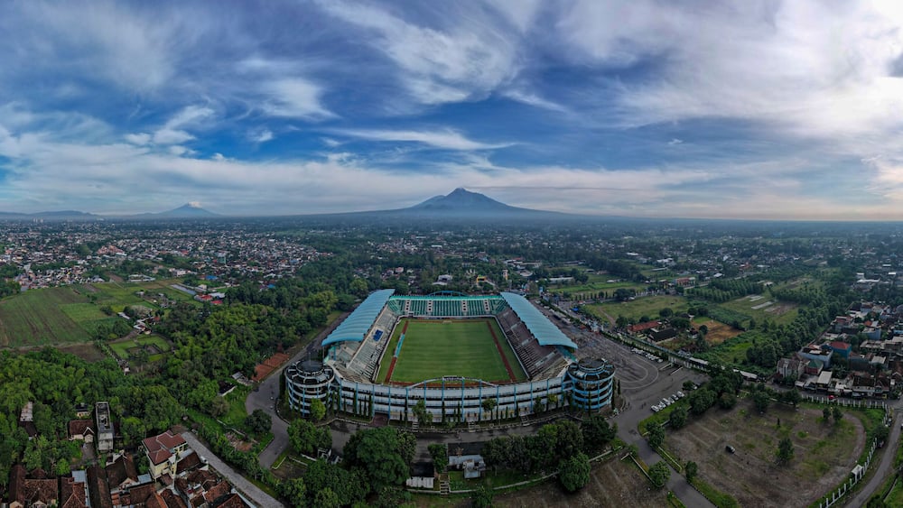 Sleman Yogyakarta, April 6, 2022 : View of Maguwoharjo Stadium from the air on a sunny morning. view of the stadium against the backdrop of the majestic Mount Merapi.