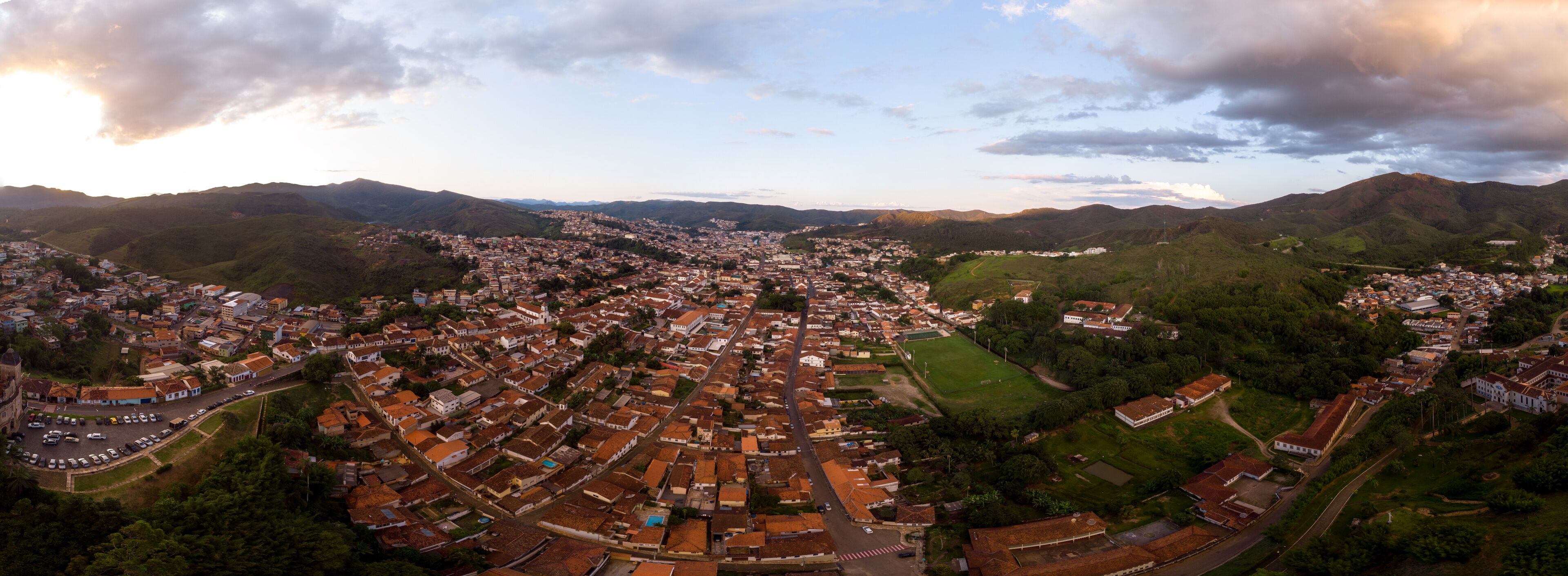 Aerial 360 degrees panorama of a Minas Gerais valley with the colonial mining city and former gold capital Mariana in Brazil at sunset against a blue sky with clouds
