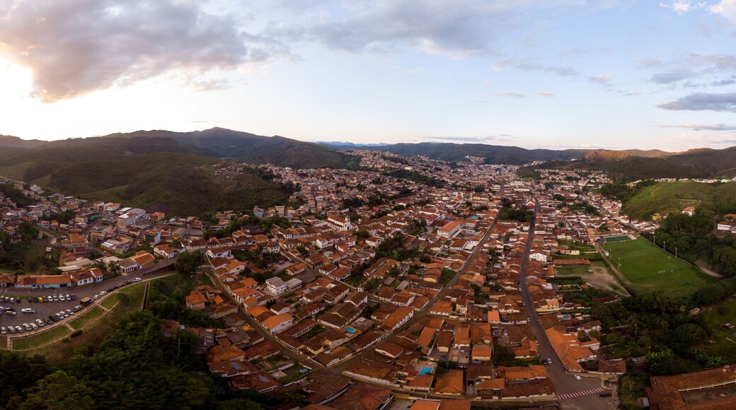 Aerial 360 degrees panorama of a Minas Gerais valley with the colonial mining city and former gold capital Mariana in Brazil at sunset against a blue sky with clouds