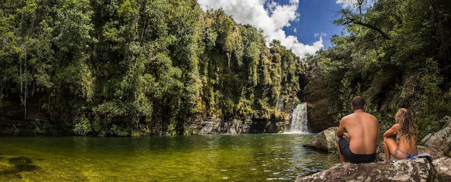 A beautiful couple watching waterfall in tropical rainforest