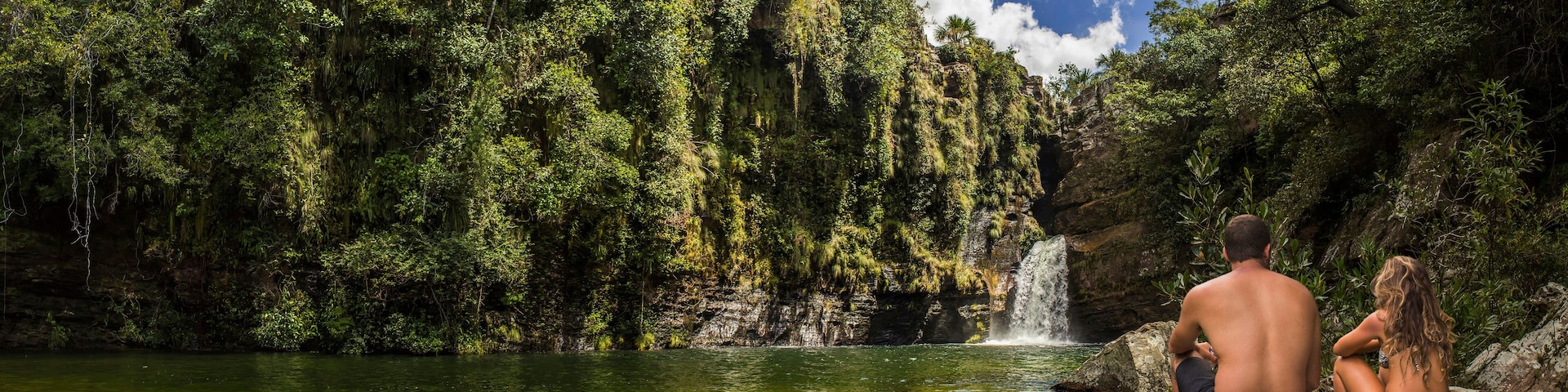 A beautiful couple watching waterfall in tropical rainforest