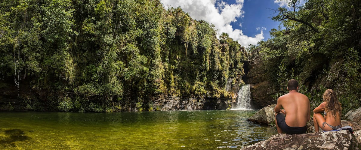 A waterfall in a lush green forest.