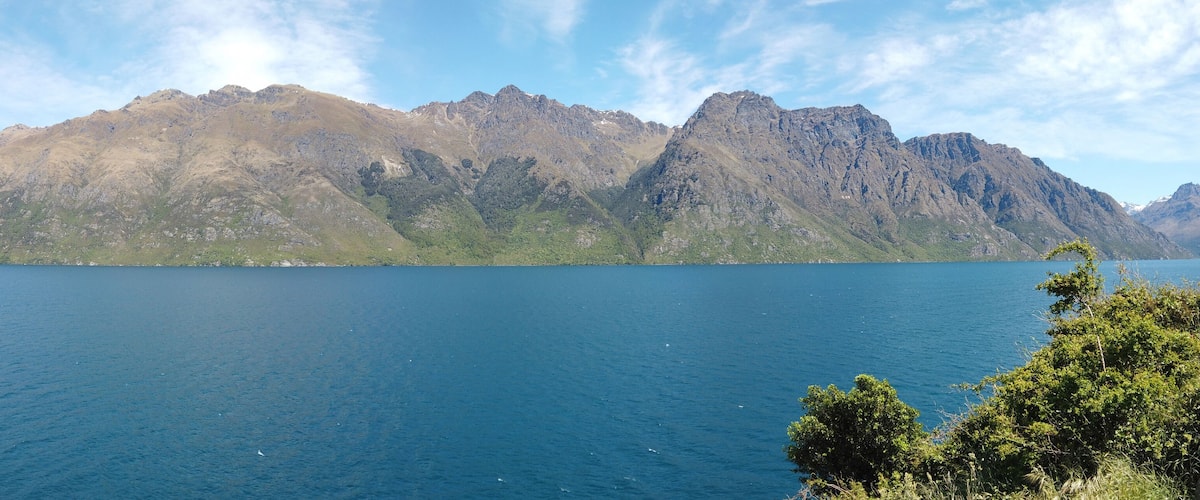 A mountain range with a lake in the foreground.