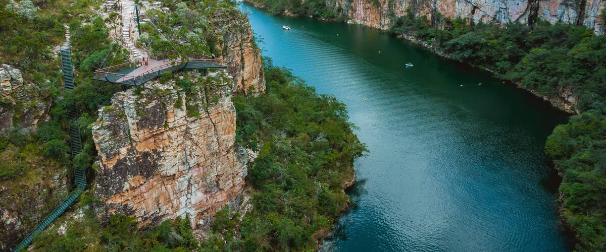 A river winding through a canyon with a bridge and a boat.