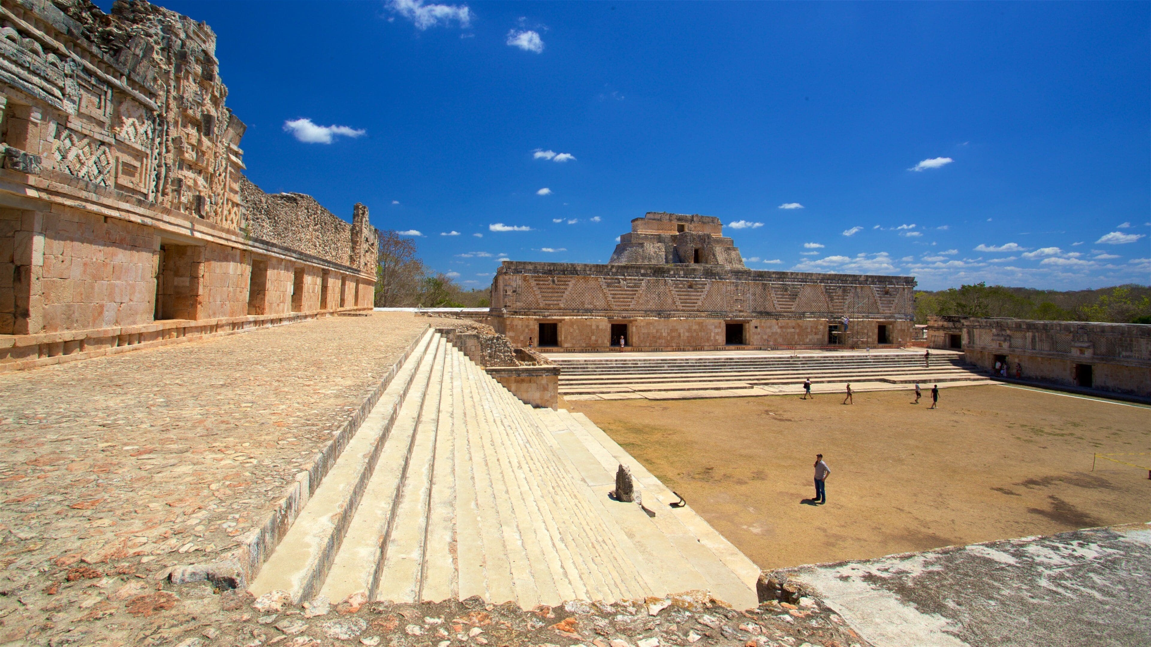 An ancient stone structure with stepped platforms and a large open courtyard.