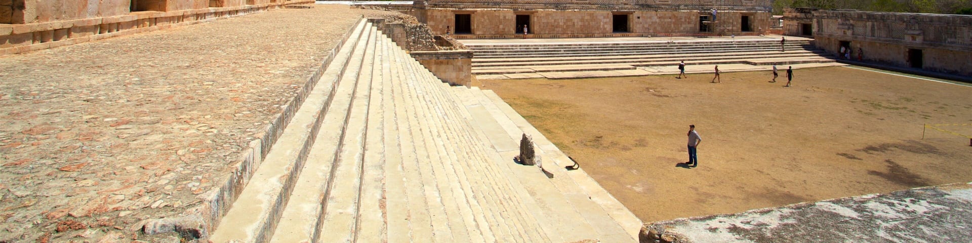 An ancient stone structure with stepped platforms and a large open courtyard.