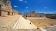 An ancient stone structure with stepped platforms and a large open courtyard.