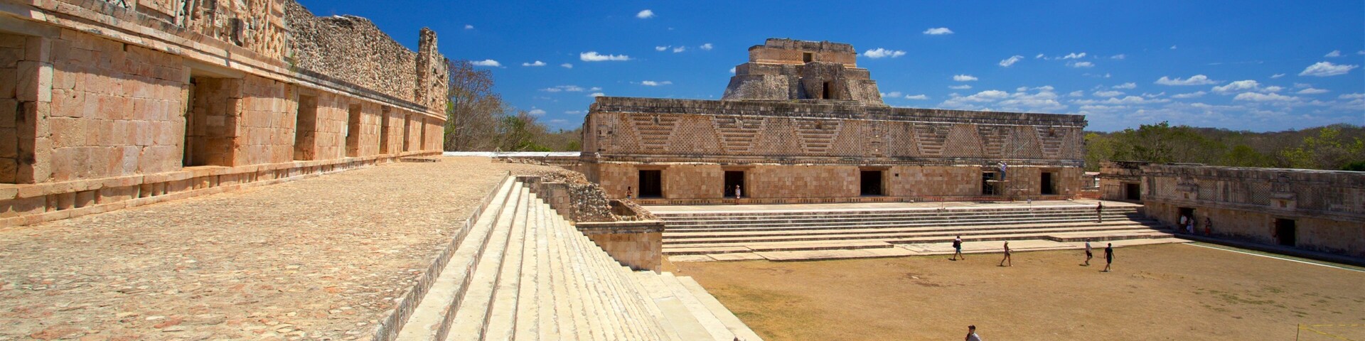 Una estructura antigua de piedra con plataformas escalonadas y un amplio patio abierto.