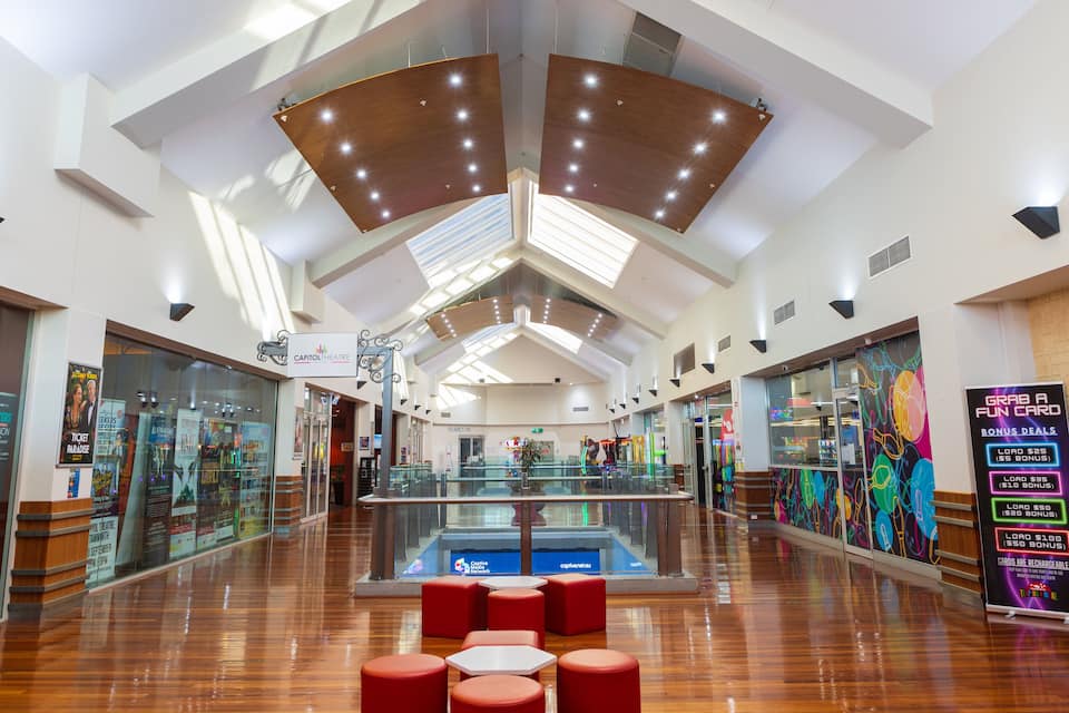 Un centro comercial amplio con techos altos, detalles de madera y un atrio central.
