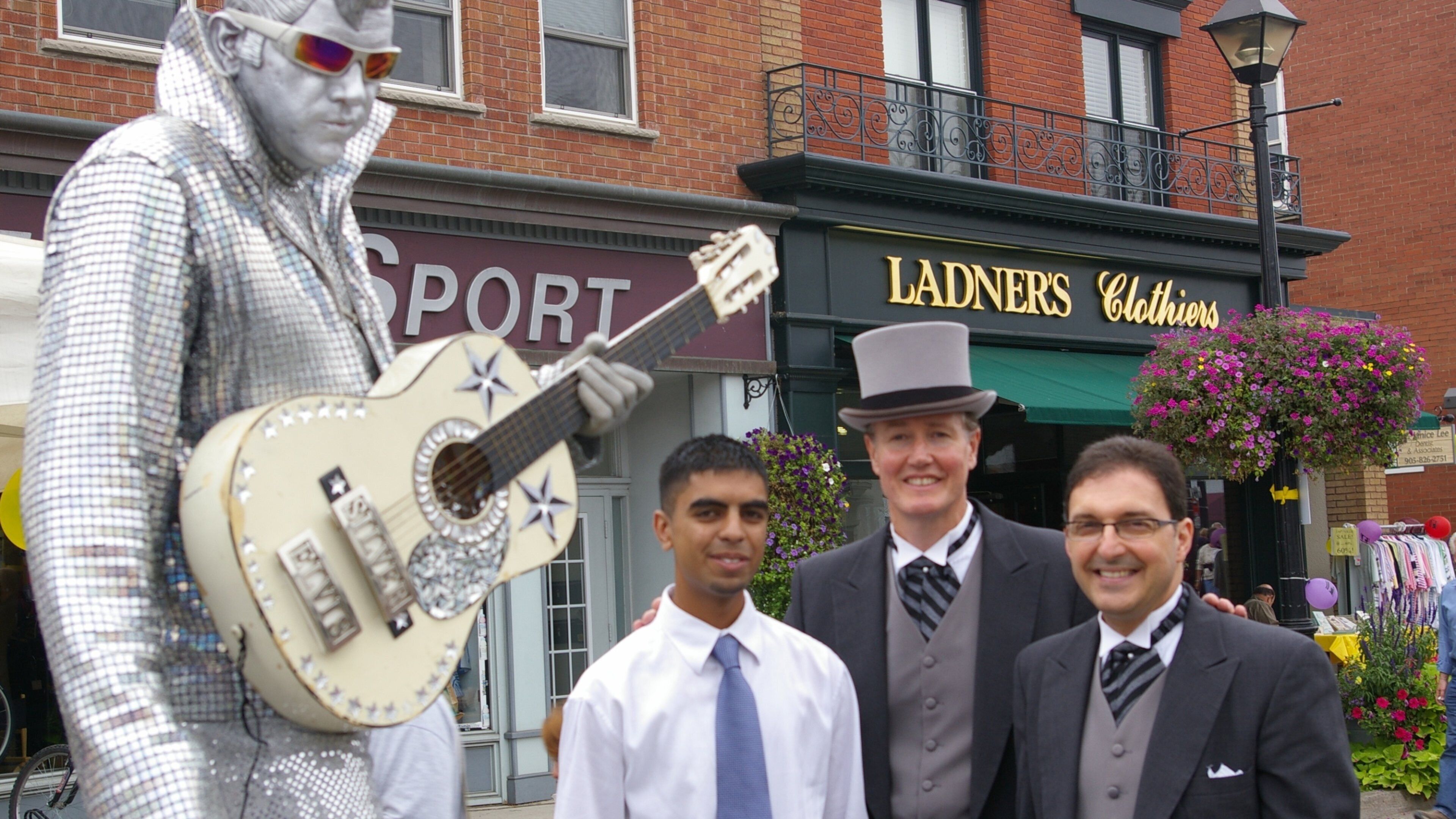 Streetsville som inkluderar en staty eller skulptur och skyltar såväl som en liten grupp av människor