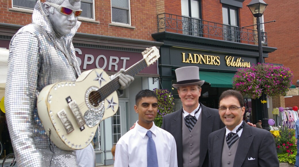 Streetsville som inkluderar en staty eller skulptur och skyltar såväl som en liten grupp av människor